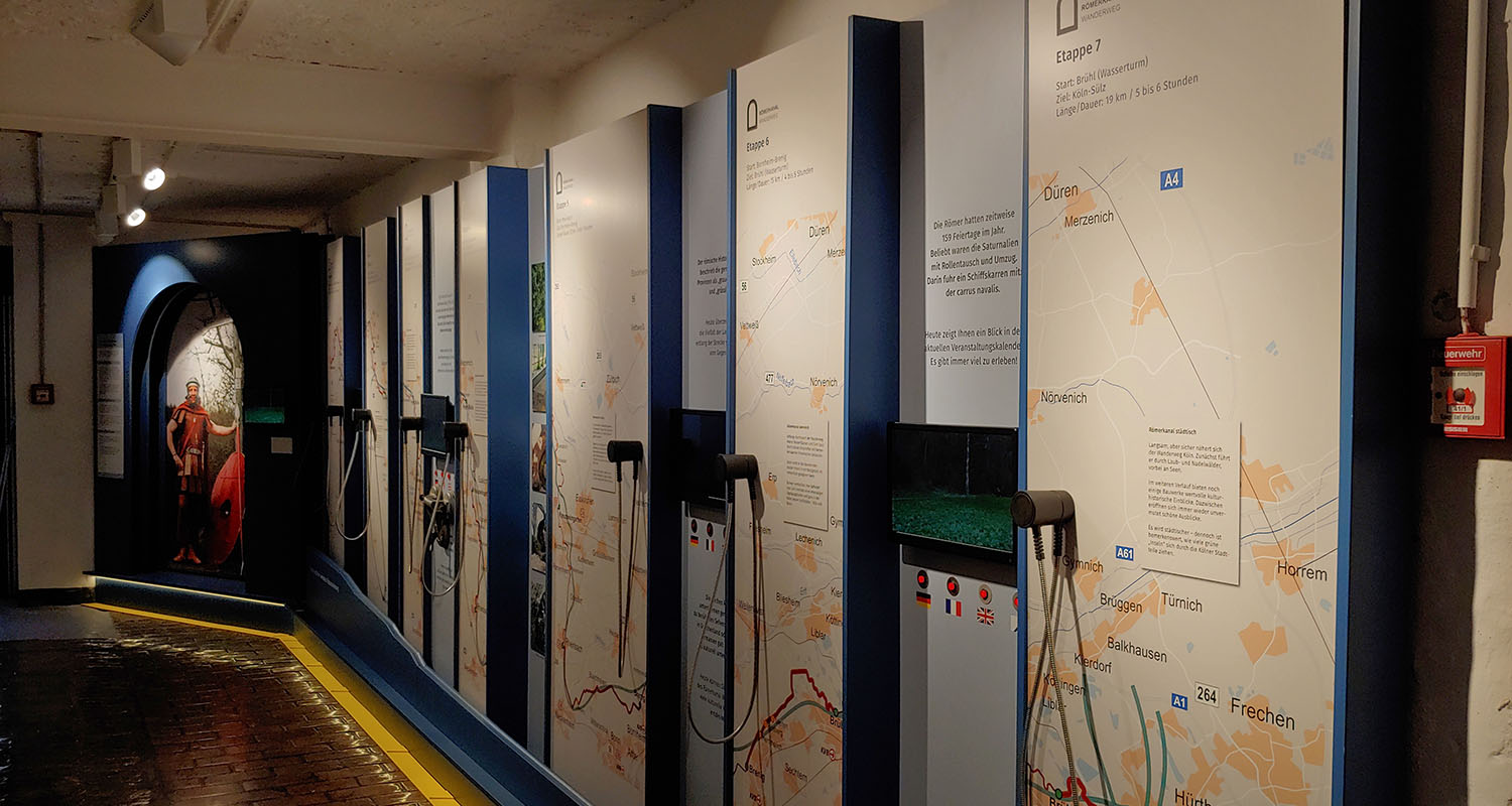 Die Ausstellungswand zeigt die verschiedenen Etappen des Römerkanal Wanderweges